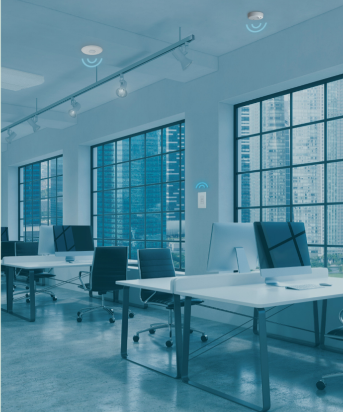 Una oficina moderna con gráficos superpuestos que muestran sensores inteligentes en el techo y las paredes.